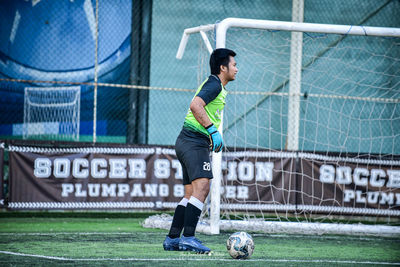 Full length of man playing soccer ball on field