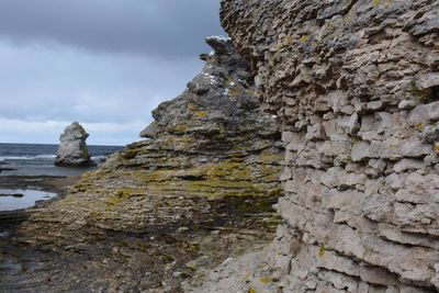 Rock formations by sea against sky