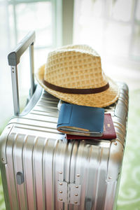 Close-up of wallet and hat on luggage