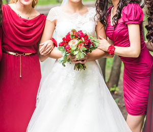 Midsection of bride holding bouquet