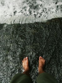 Low section of man standing on water