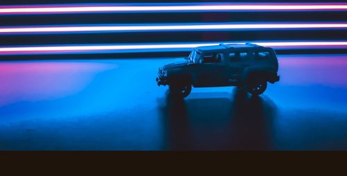 Close-up of toy car on table against illuminated wall