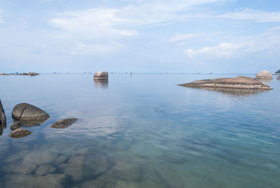 Islands in sea against cloudy sky