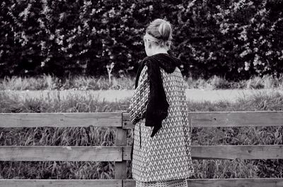 Woman standing against fence