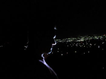 Illuminated city against sky at night