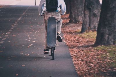 Low section of person riding motorcycle on road