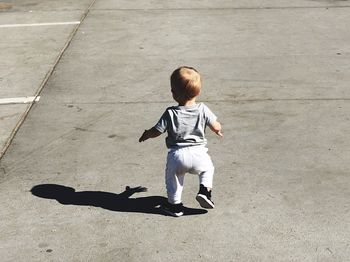 Rear view of boy walking on ground