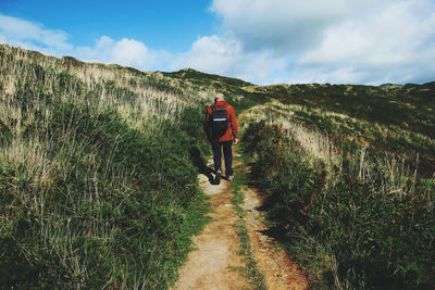 Rear view of senior man walking on footpath