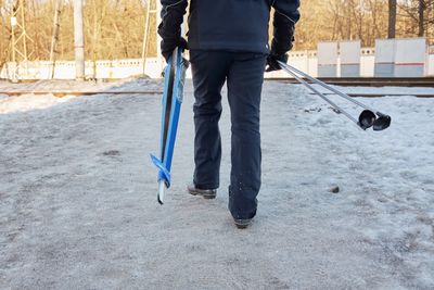 Man goes cross-country skiing to forest in winter. person has skis and sticks in hands