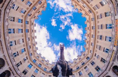 Low angle view of modern building against cloudy sky