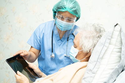 Doctor showing digital tablet to patient at hospital