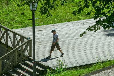 Full length of boy running on plants