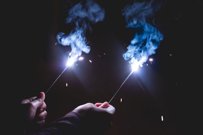 Person holding sparklers at night