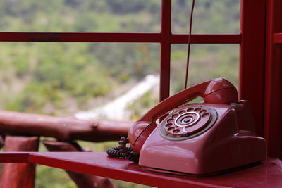 Close-up of telephone booth against window