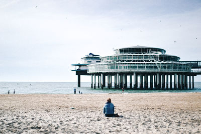 Rear view of people sitting on beach