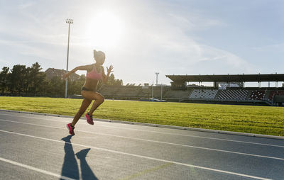 Female athlete running on racetrack