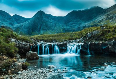 Scenic view of waterfall against sky