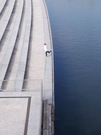 High angle view of woman standing on leg by sea