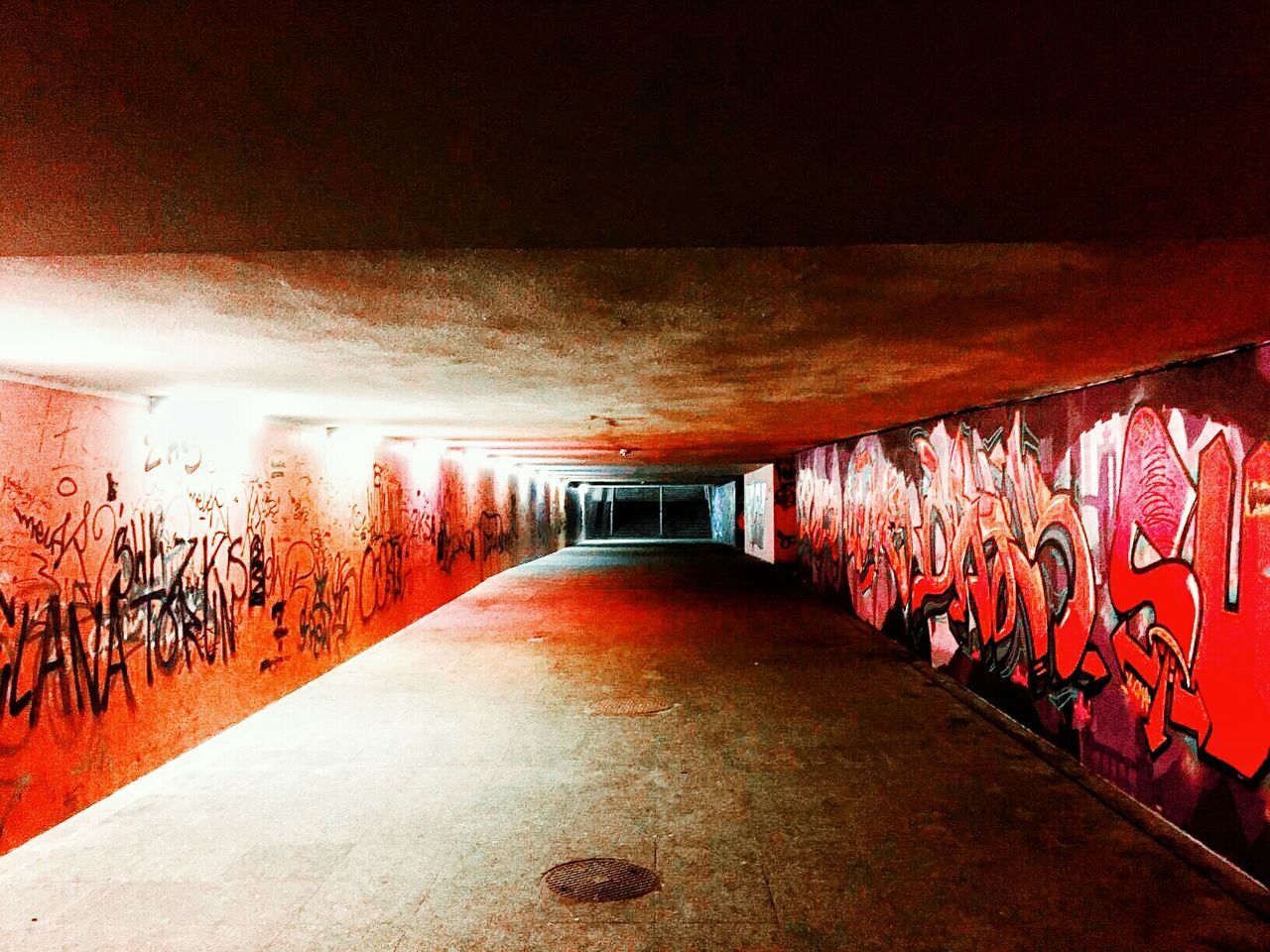 graffiti, art, wall - building feature, creativity, built structure, art and craft, text, the way forward, architecture, illuminated, diminishing perspective, wall, street art, multi colored, western script, tunnel, no people, indoors, vanishing point, lighting equipment