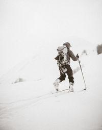 Rear view of person skiing on snowcapped mountain