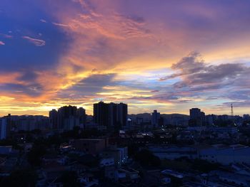 High angle view of silhouette buildings against sky during sunset