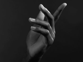 Close-up of human hand against black background