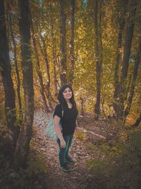 Portrait of young woman in forest during autumn