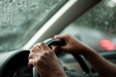 Cropped hands of person driving car