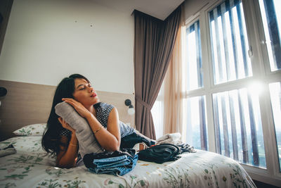 Young woman lying on bed at home