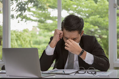 Young man using mobile phone while sitting on table