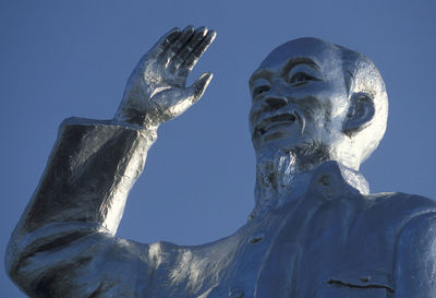 Low angle view of ho chi minh statue against clear blue sky
