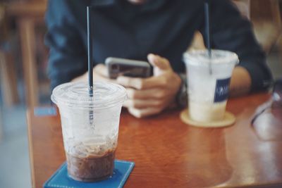 Midsection of man holding coffee cup