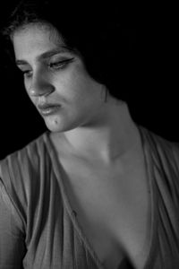 Close-up portrait of beautiful young woman over black background