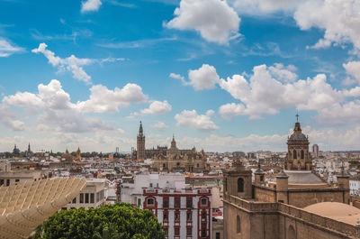 Buildings in city against cloudy sky