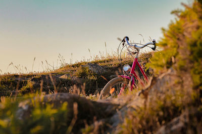 Bicycle parked on land against sky