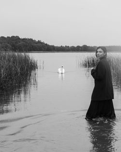 Portrait of man standing in lake against sky