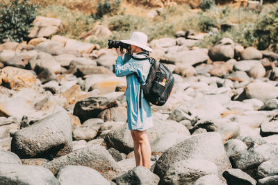 Rear view of woman standing on rocks