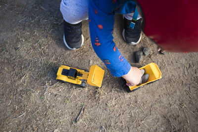 High angle view of boy playing with toy construction vehicles.