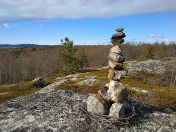 Stack of rocks on land against sky