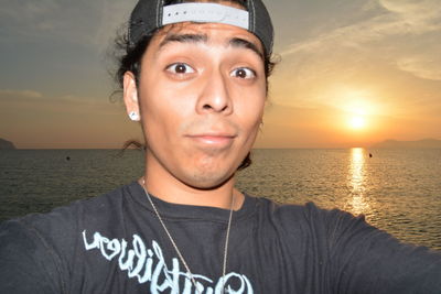 Portrait of man at beach against sky during sunset