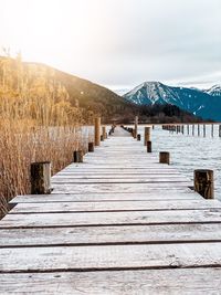 Wooden posts on snowcapped mountains against sky