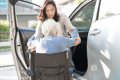 Asian senior or elderly old lady woman patient sitting on wheelchair prepare get to her car 