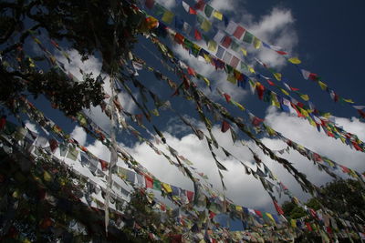 Low angle view of buddhism flags against sky at monastery