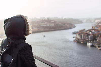 Rear view of man looking at sea against sky