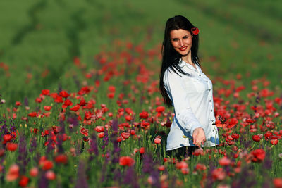 Portrait of smiling young woman standing on field