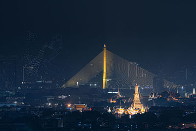 Illuminated city against clear sky at night