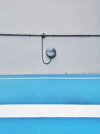 Round lamp on plaster wall and blue floor