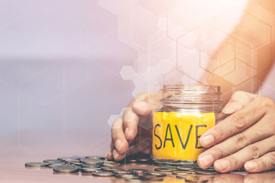 Midsection of woman holding ice cream in jar on table