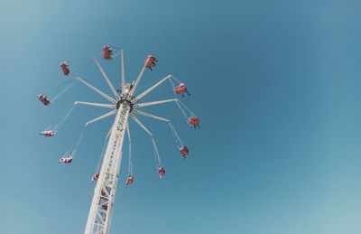 Low angle view of chain swing ride against clear sky at coney island