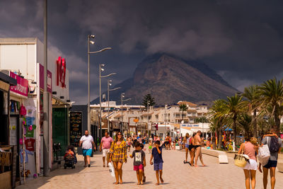 People on street in city against sky